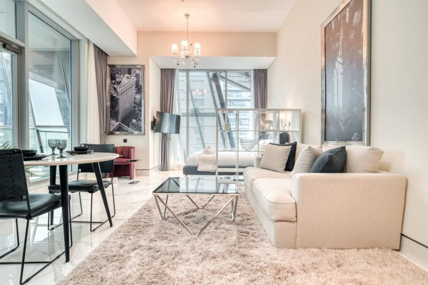 Ein modernes Wohnzimmer mit einem Glastisch, einer Couch und einem Essbereich mit Tisch und Stühlen.