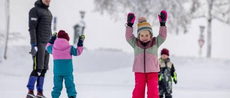 A snowy outdoor scene with people skiing and snowboarding.