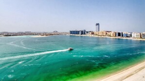 A coastal cityscape with a clear blue sea, a sandy beach, and modern high-rise buildings. - Sea view 2BR Beach Isle (Dubai)