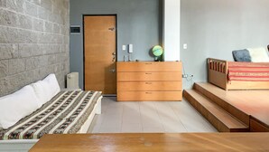 Un dormitorio con una cama, un aparador, un globo terráqueo y un banco de madera.