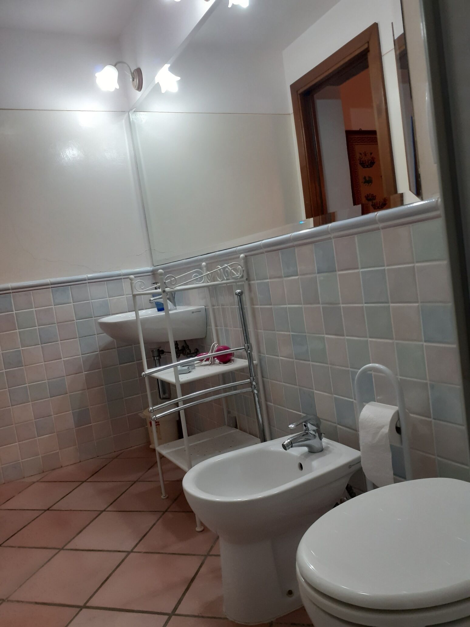 A bathroom with a bidet, a sink, and a toilet.
