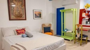 Une chambre à coucher avec un lit, une chaise, un bureau et une armoire.