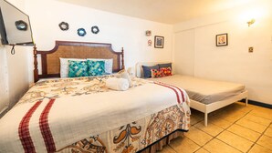 Une chambre d’hôtel avec un grand lit, un lit plus petit et une table de chevet.