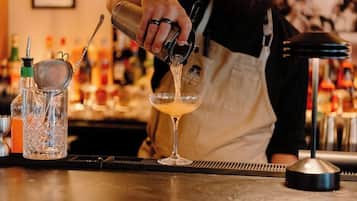 Un bartender vertiendo una bebida en un vaso.