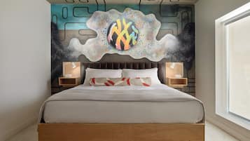 A modern bedroom with a bed, two bedside tables, a wall mural, and a large window.