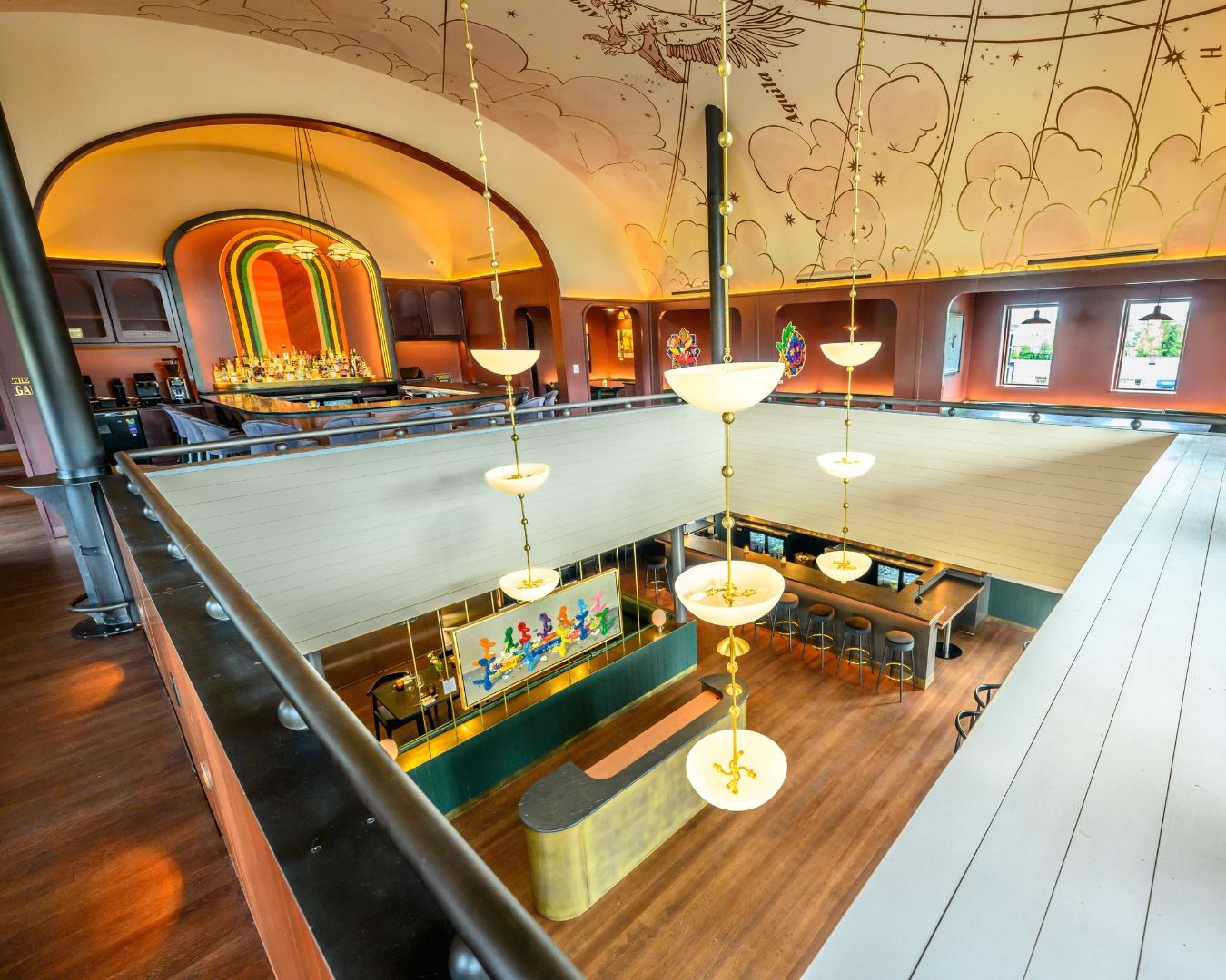 Een ruime bar met verschillende zitplaatsen en een podium op de achtergrond.