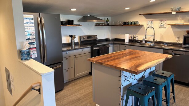 A modern kitchen with a central island, stainless steel appliances, and wooden countertops. - The Asbury House Guest Rentals (Moscow)