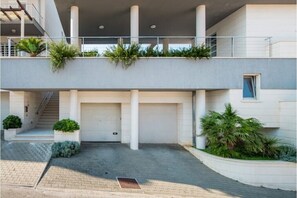 A modern building with a covered entrance, a staircase, and a garage.