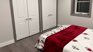 A bedroom with a bed, two white doors, and a window with blinds. - Beautiful house on farm, Nature lover's paradise (Rosemont)