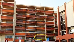 Een meerhoog gebouw met balkons, een bar genaamd 'Bar Glacier' en een restaurant met de naam 'Creperie Snack'.