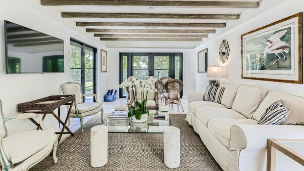 A spacious living room with a high ceiling, large windows, and a mix of modern and classic furniture. - Cortez Bungalow, 3 Bd 2 Ba, Private Pool (West Palm Beach)