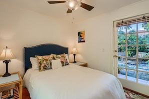 Relax in comfort with a large bed, bedside tables, and a ceiling fan.