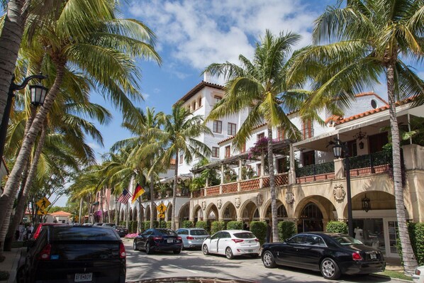 Classic hotel with a central entrance, arched windows, and a balcony with wrought iron railing.