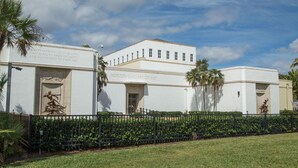 The exterior of the Norton Gallery of Art, featuring a white building with a flat roof, a black fence, and palm trees. - Key Lime Bungalow 2 BD 1 BA With Private Pool (West Palm Beach)