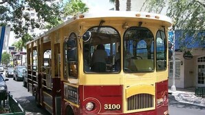 A vintage yellow and red bus with the number 3100 on the front, parked on a city street.