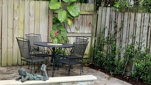 A pool with a stone edge and a small waterfall feature. - Nini's Cottage 4bd 3ba Vacation Rental (West Palm Beach)