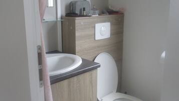 Un baño con inodoro, lavabo y espejo.