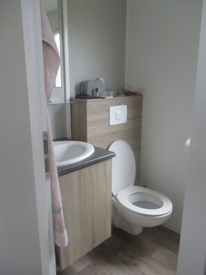 Ein Badezimmer mit Toilette, Waschbecken und Spiegel.