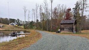 A gravel path leading to a wooden cabin by a pond with a dock and chairs. - Cabin on Pond and Vineyard next to Aging Cave (Chapel Hill)