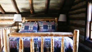 A rustic wooden bed with plaid bedding and two bedside lamps in a log cabin room. - Cabin on Pond and Vineyard next to Aging Cave (Chapel Hill)