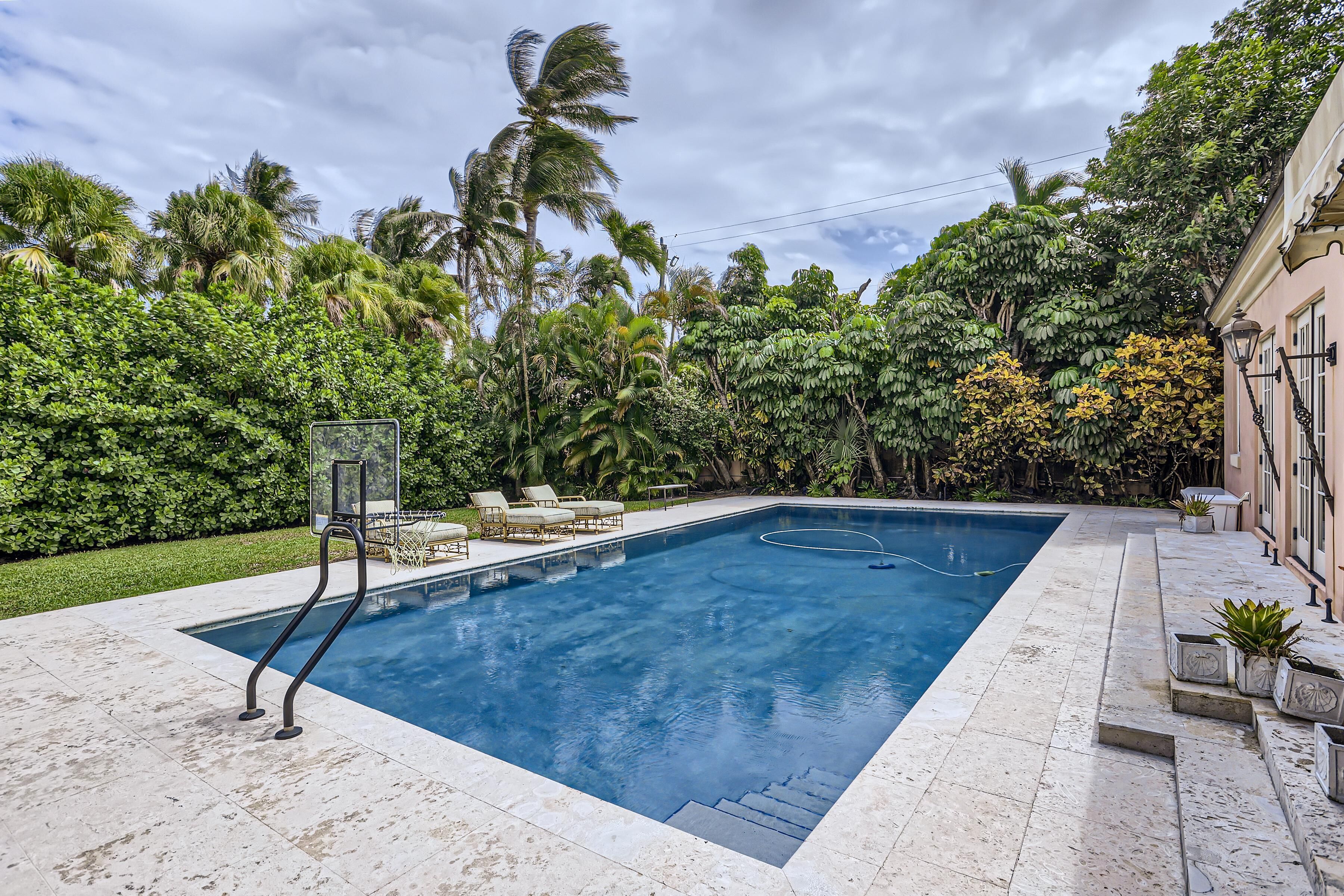 A rectangular swimming pool with a clear blue water surface, surrounded by a tiled deck.