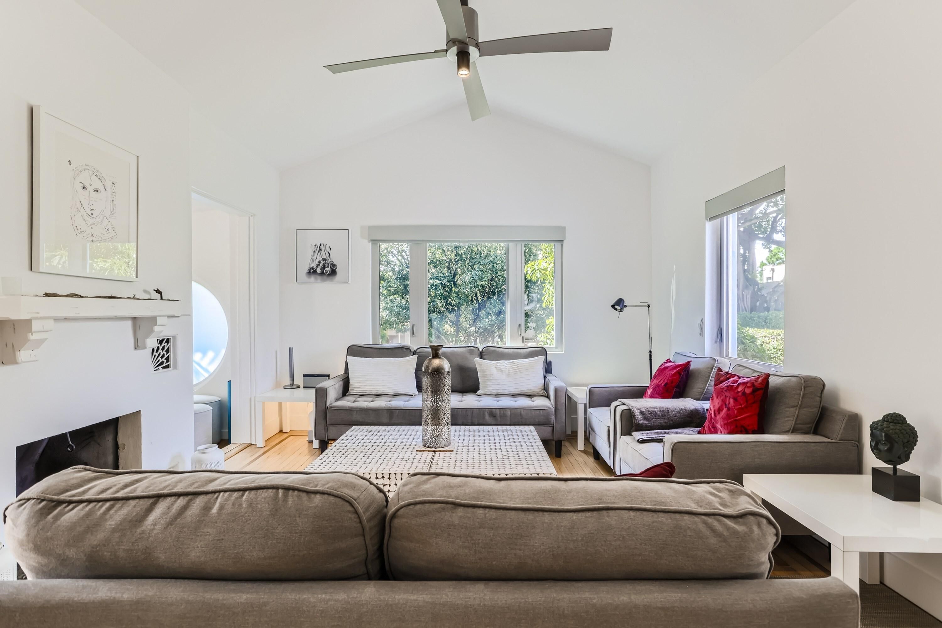 A modern living room with a sofa, a coffee table, and a fireplace.