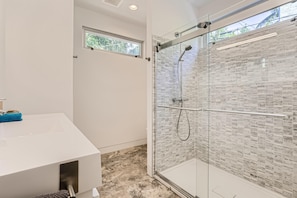 A modern bathroom with a glass-enclosed shower, a white sink, and a window providing natural light. - Villa Ardmore, 3 Bedrooms, 3.5 Baths, Pool (West Palm Beach)