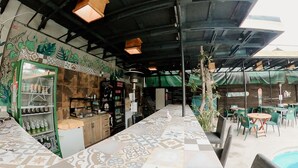 Un restaurante con piso de baldosas, zona de bar y mesas al aire libre.