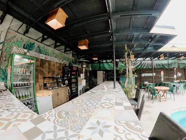 A restaurant with a tiled floor, a bar area, and outdoor seating.