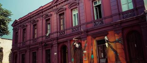 Un edificio histórico con fachada simétrica, ventanas grandes y una entrada destacada.