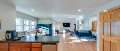 A spacious kitchen with wooden cabinets, a central island, and a dining area with a sofa.