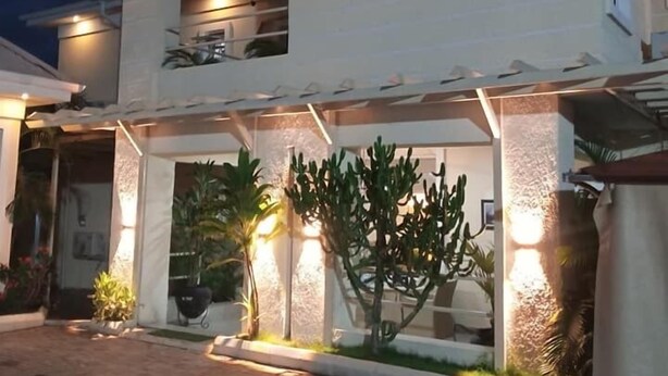 Une maison à deux étages, dotée d’une entrée bien éclairée et d’un patio couvert.