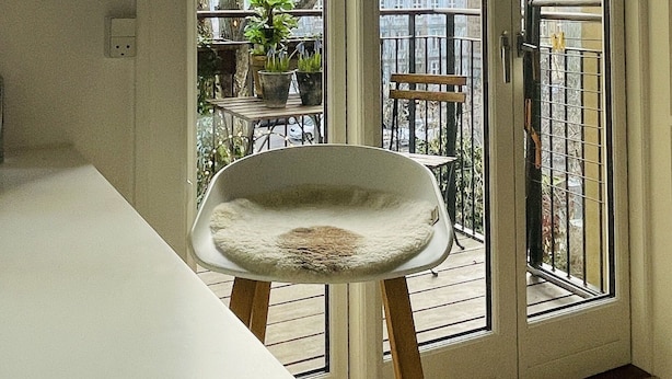 A room with a large window, a white table, and a chair.