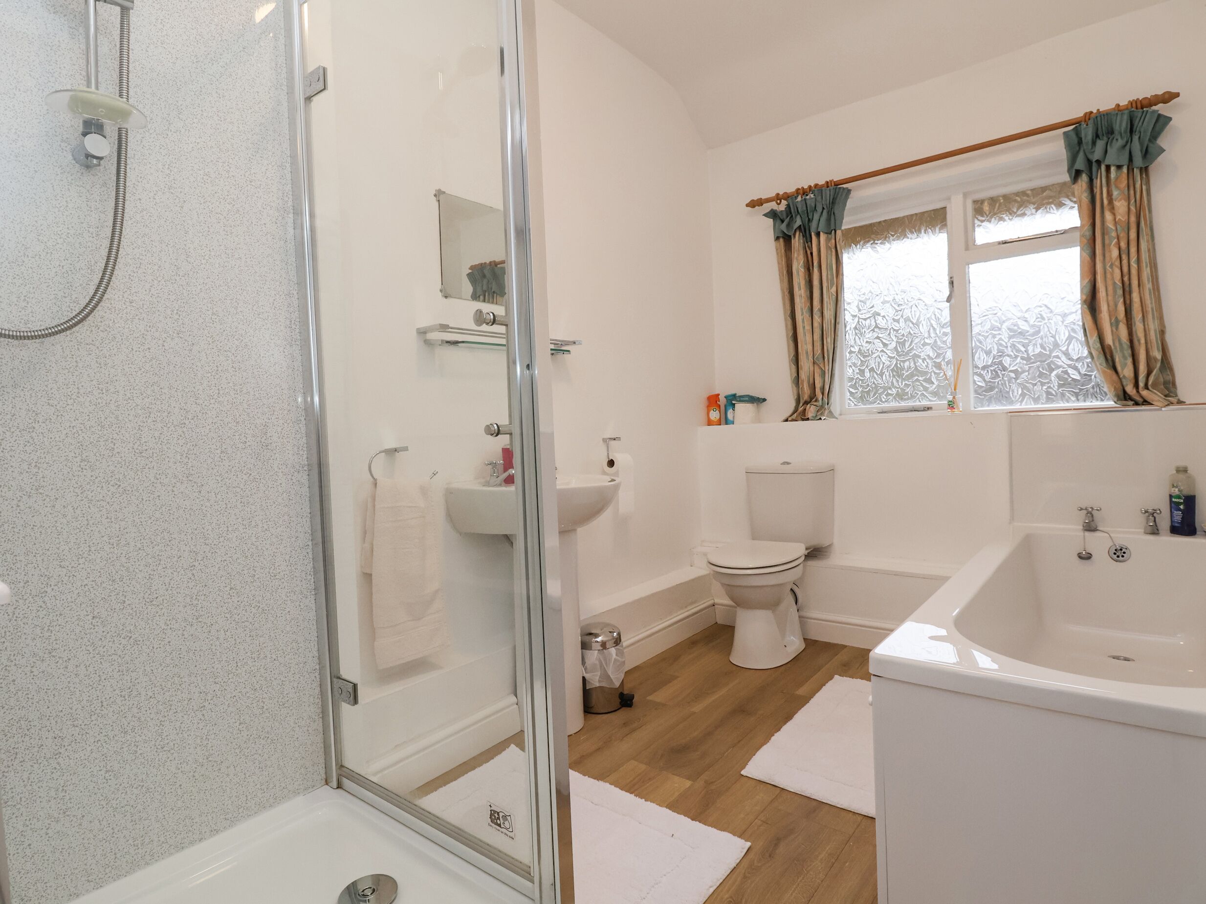 A bathroom with a glass shower enclosure, a toilet, a sink, and a bathtub.