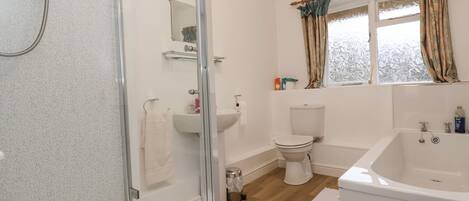 A bathroom with a glass shower enclosure, a toilet, a sink, and a bathtub.