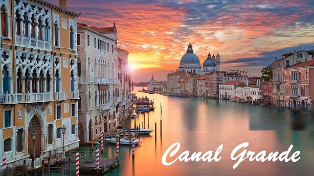 A canal with historic buildings and a sunset.