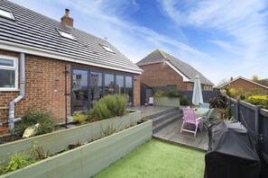 A residential backyard with a patio, a covered barbecue area, and a brick house. - Not for rent as using back as own house cannot cancel trying to (Canterbury)