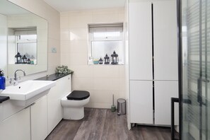 A modern bathroom with a white sink, toilet, and a glass shower enclosure. - Not for rent as using back as own house cannot cancel trying to (Canterbury)