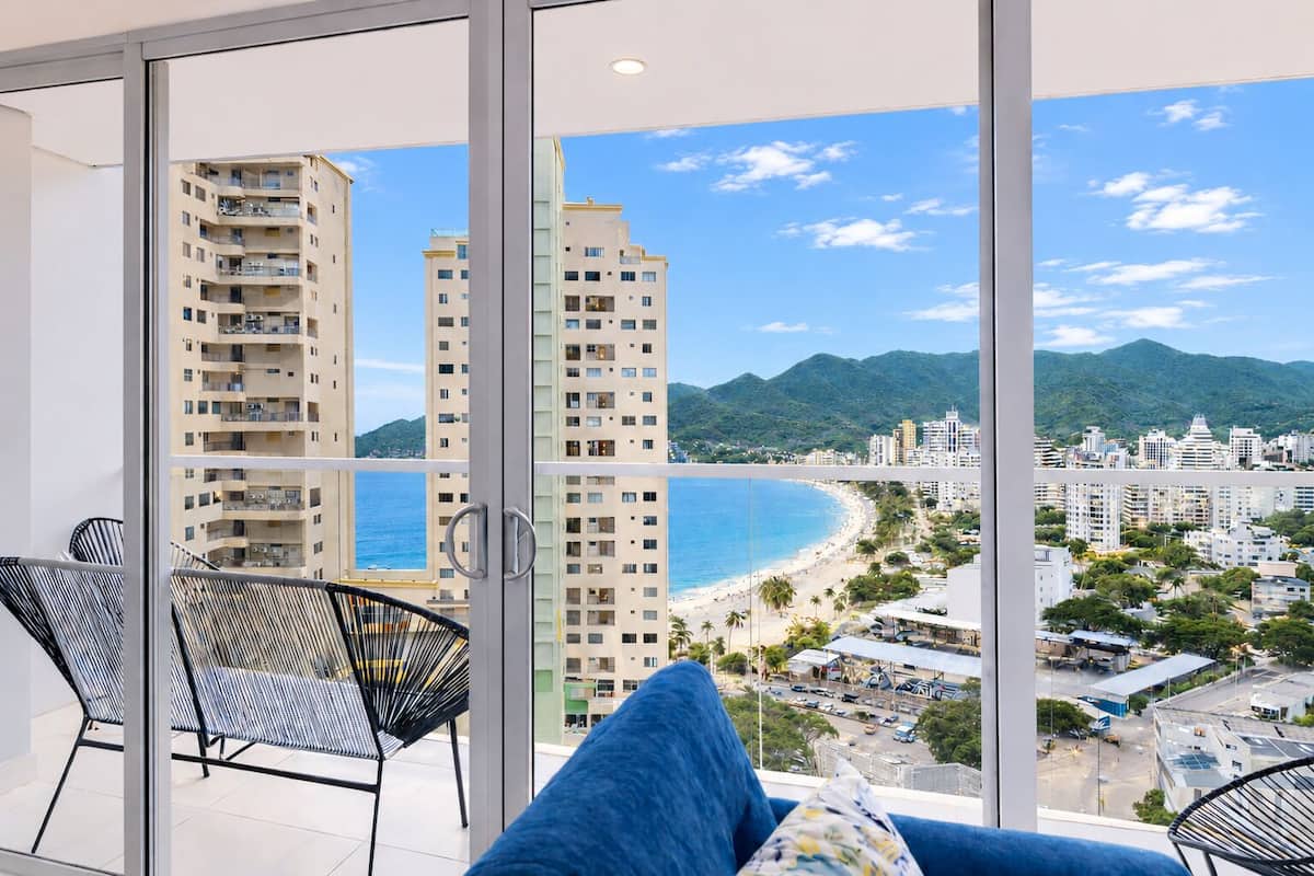 A balcony with a view of a beach and high-rise buildings.