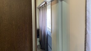 A hallway with a wooden door, a window with curtains, and a door leading to another room. - Cares Apartament, Castelar Centro, Buenos Aires. (Castelar)