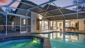 Uma piscina com área coberta, um pátio e vista para a paisagem ao redor.