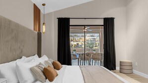 A modern hotel room with a large bed, a ceiling fan, and a view of the outdoor patio area. - Luxury 4BD 3BA Free Heated Pool Villa/Fenced Backyard (Davenport)