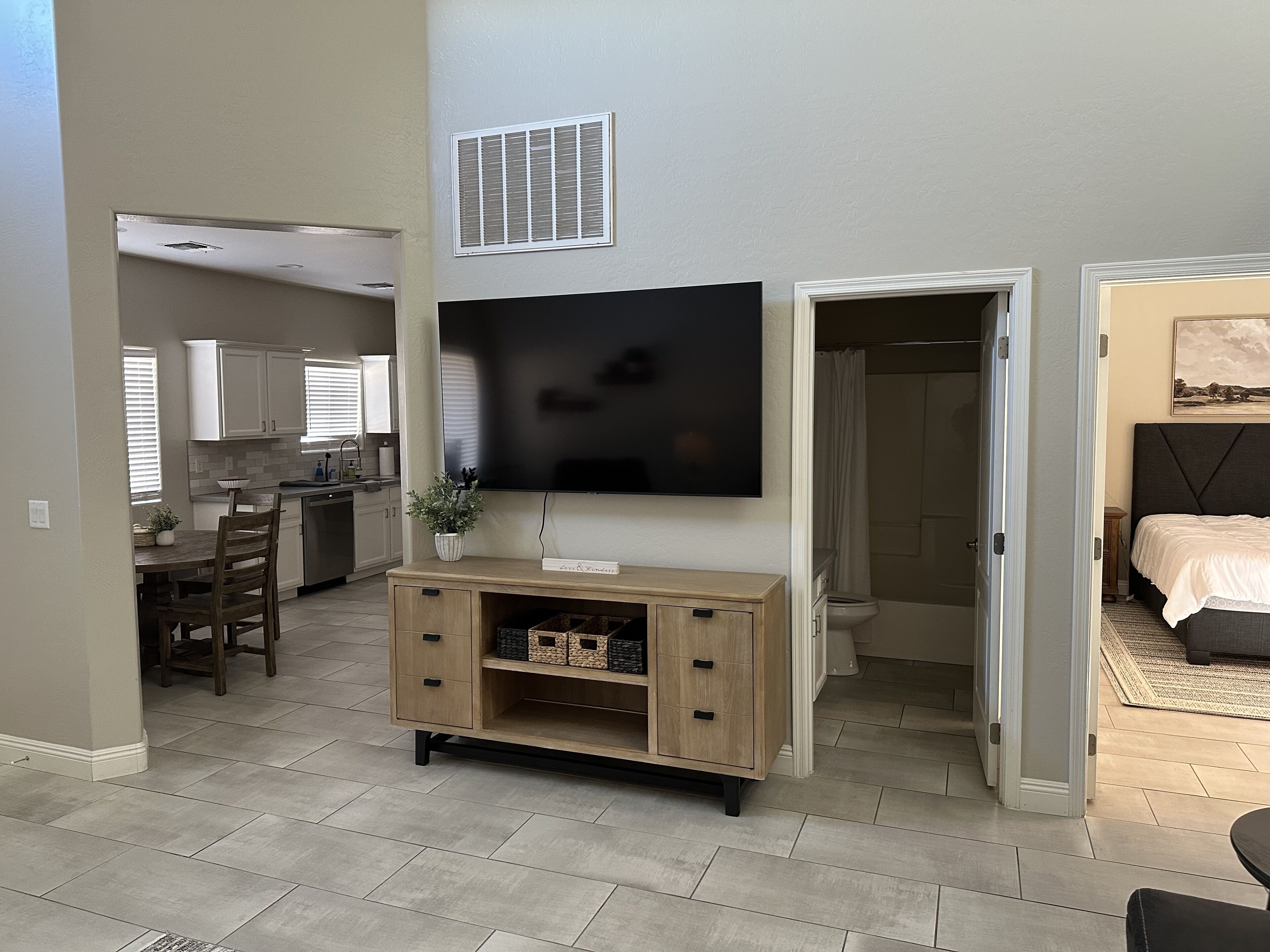 A modern living space with a kitchen, dining area, and a bedroom.