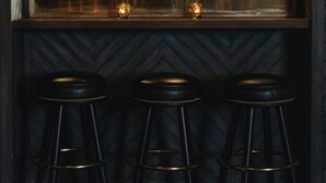 A bar area with a wooden ceiling, a sign that reads "ON THE AIR," and three black stools with gold accents. - Gold-Diggers Hotel (Los Angeles)