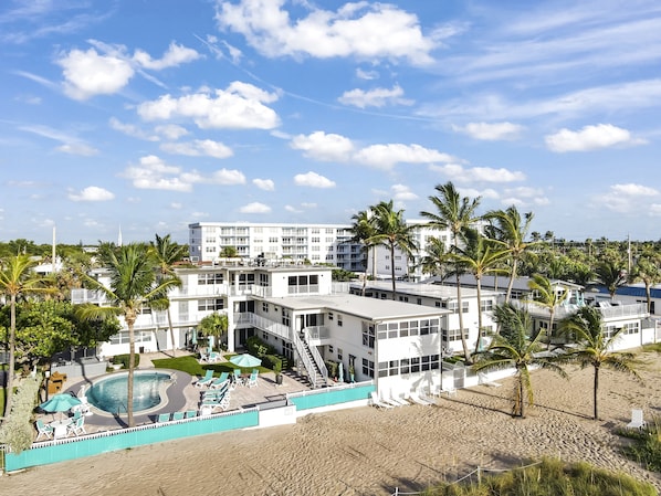 A resort with a pool, multiple buildings, and palm trees. - Beachfront Penthouse~Private Deck View~Heated Pool (Lauderdale by the Sea)