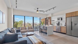 Ein modernes Apartment mit Wohnzimmer, Küche und Balkon.