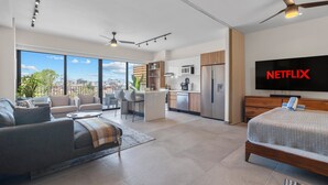 Eine moderne Wohnung mit Wohnzimmer, Küchenzeile und Schlafzimmer.