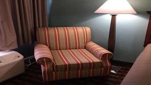 A striped armchair in a hotel room with a lamp and a ceiling light. - Deluxe 2 Double Beds in Music Valley (Nashville)