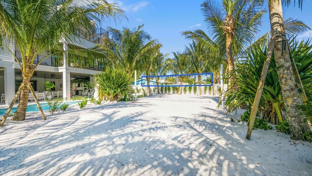 A resort with a pool, palm trees, and a covered walkway. - Lagoon Pool/Slide/Spa - Beach Volleyball/Ping Pong (Sarasota)
