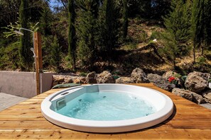 A hot tub on a wooden deck with a natural backdrop of trees and rocks. - Nightingale Villa & Suites- Jiannis Villa (Corfu)